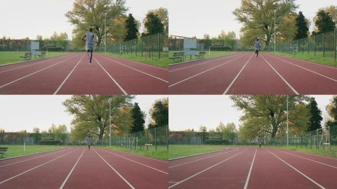 年轻的非洲男运动员的慢动作在体育馆的赛道上奔跑