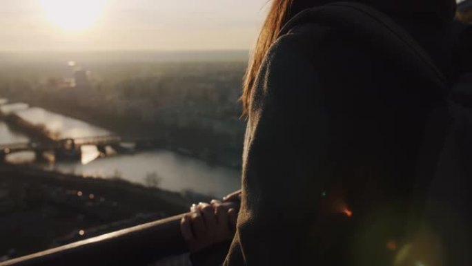 电影在年轻快乐的旅游女人微笑着，在埃菲尔铁塔慢动作上观看巴黎天空美景。