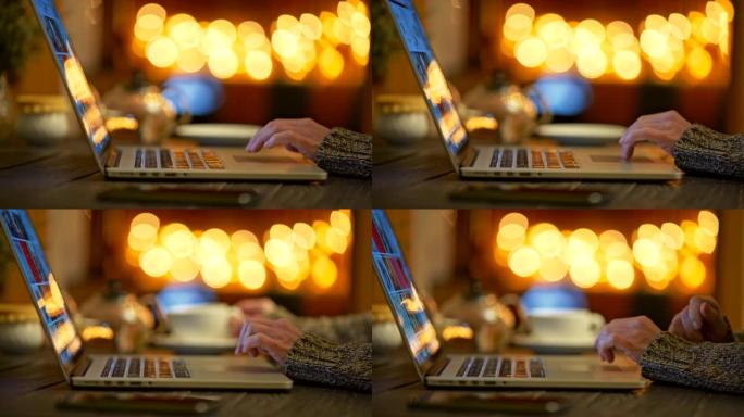 女人穿着毛衣，喝了一口咖啡，通过笔记本电脑上网。明亮的黄色圆圈bokeh背景。滑动镜头，4K