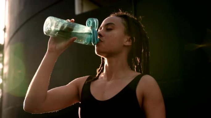 城市4k中年轻的非洲裔美国妇女饮用水的前视图