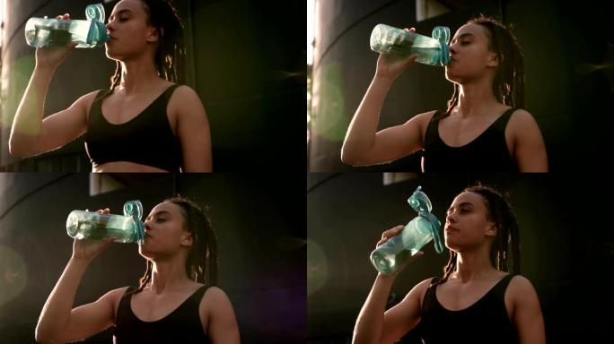 城市4k中年轻的非洲裔美国妇女饮用水的前视图
