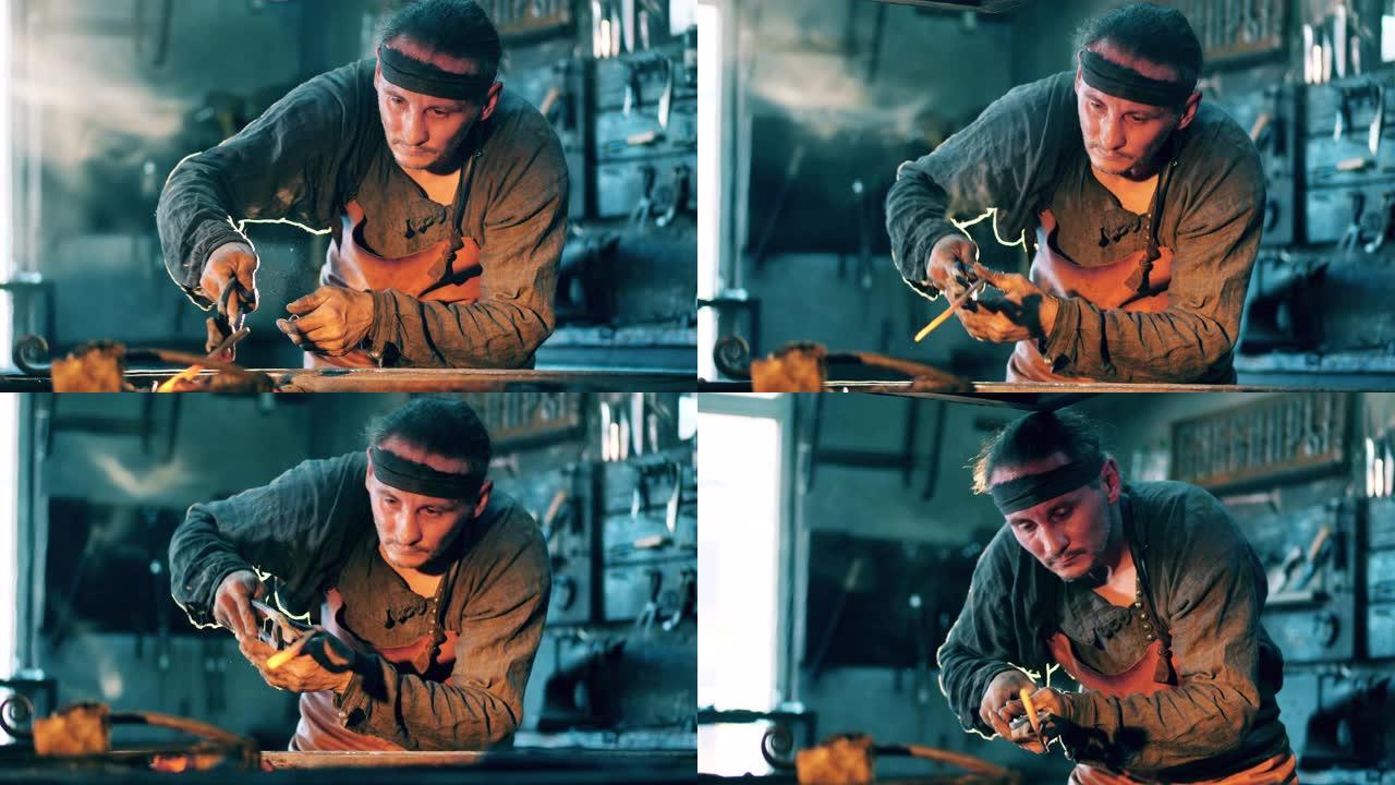 男子在锻造厂用刀工作时拿着金属钳。