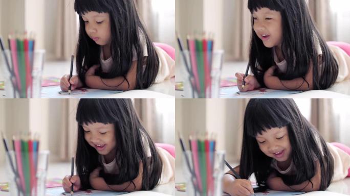 小女孩在客厅的纸质书上画作业