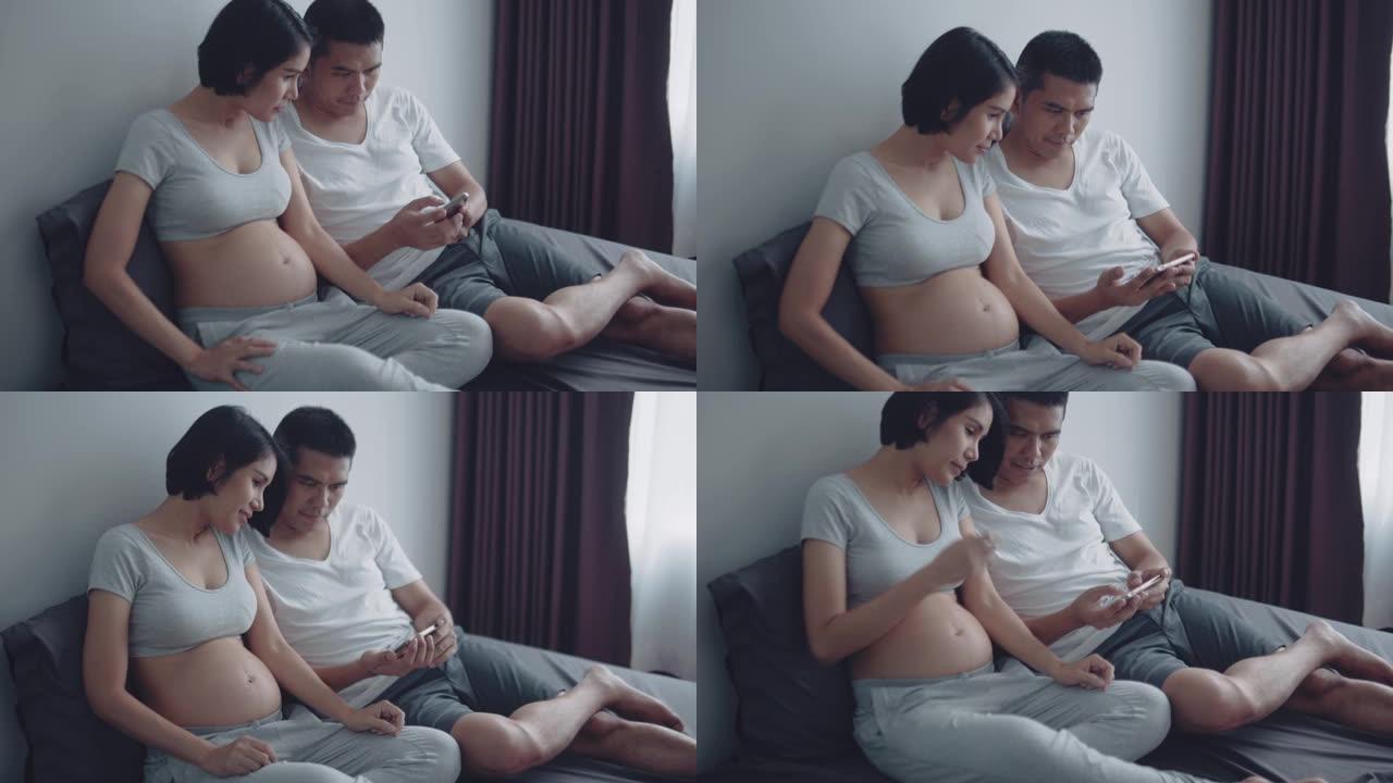怀孕夫妇在智能手机上观看超声波视频