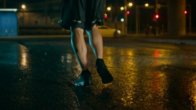 一名穿着运动服的运动青年在多雨的街道上慢跑的特写腿部镜头。他在黑暗的城市环境中奔跑，背景是汽车。