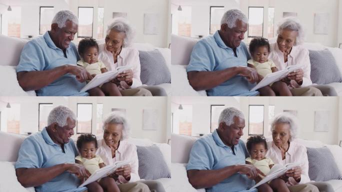 祖父母坐在沙发上与小孙女一起看书