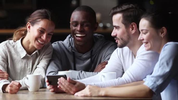 快乐的多元化伴侣在智能手机上观看有趣的视频