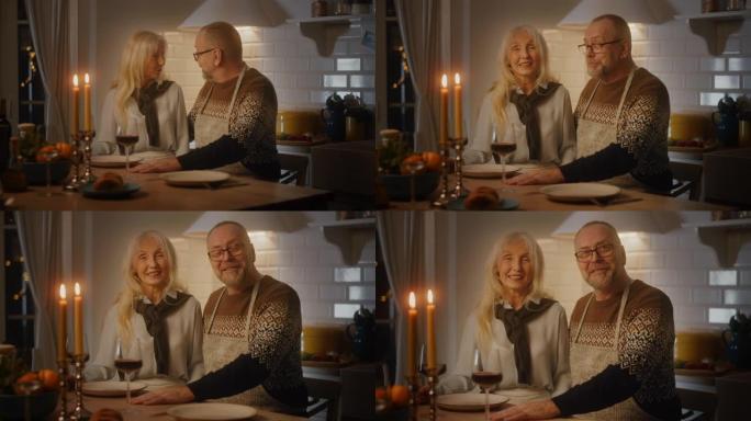 恋爱中的幸福高级夫妇度过浪漫的夜晚，在厨房做饭和晚餐，庆祝周年纪念日。老年人在舒适的厨房室内享受葡萄
