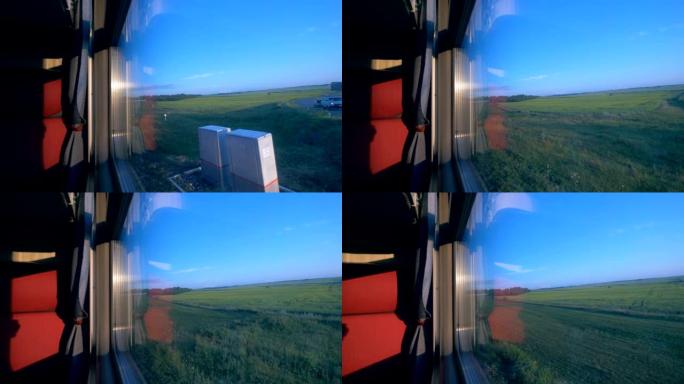 在火车车厢里穿过田野。乘火车旅行的概念。