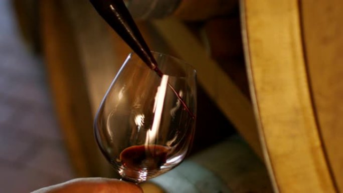 葡萄园中的侍酒师以慢动作将意大利白葡萄酒倒入玻璃杯中
