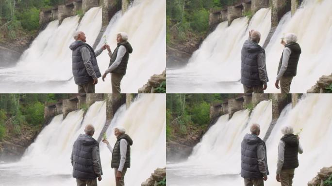 老年夫妇看着大坝溢洪道