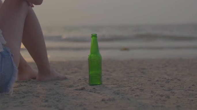 海滩上的手抓瓶女孩海边喝酒失恋孤独无助