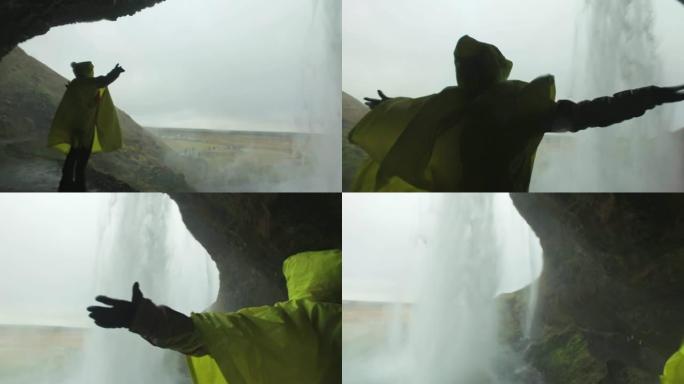 站在冰岛瀑布后面的雨中女士