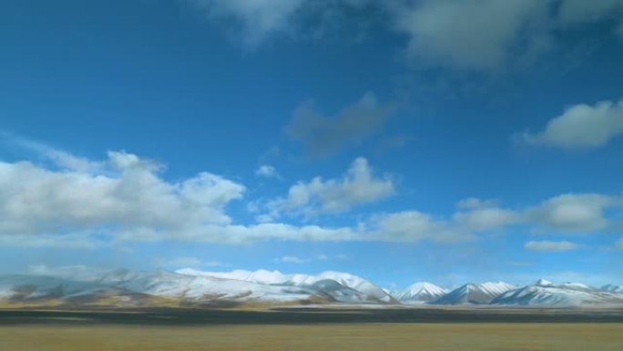 火车窗提供了平原和白雪覆盖的山脉的美丽景色。