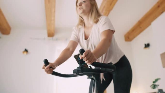 SLO MO Mid成年女性骑健身车