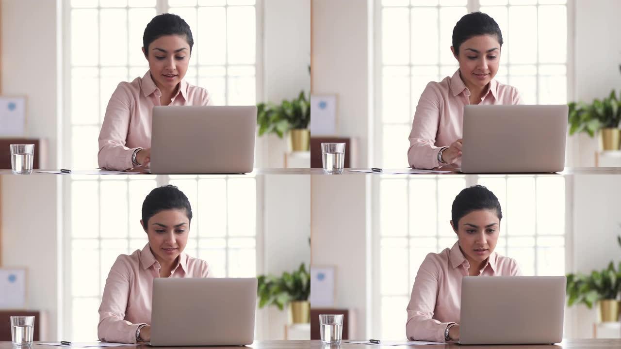年轻的印度女商人使用笔记本电脑解决了突然的在线问题