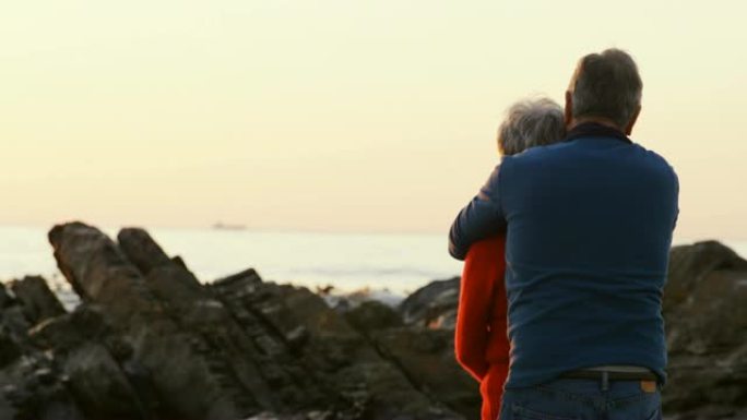 一对老年夫妇在4k沙滩上拥抱