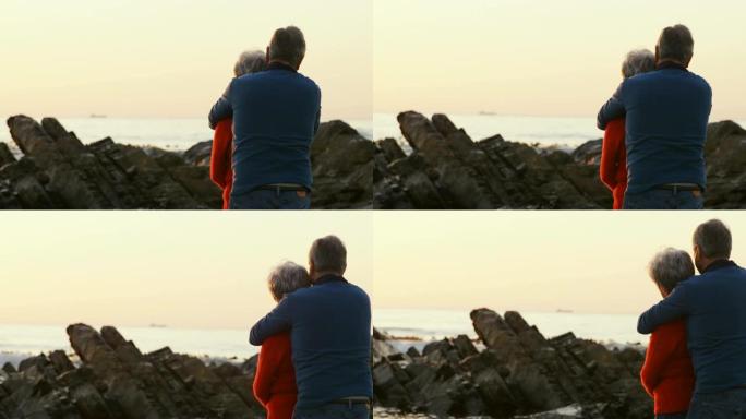 一对老年夫妇在4k沙滩上拥抱