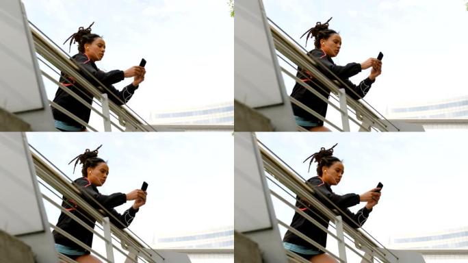 城市中使用手机的年轻非洲裔美国妇女的低角度视图4k