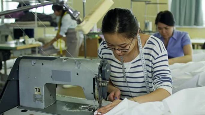 亚洲裁缝在工厂生产服装