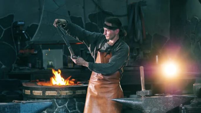 专业铁匠检查一把铁刀，站在铁匠铺上。