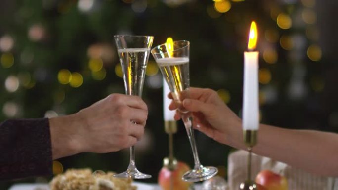 无法辨认的男人和女人在圣诞节用香槟敬酒