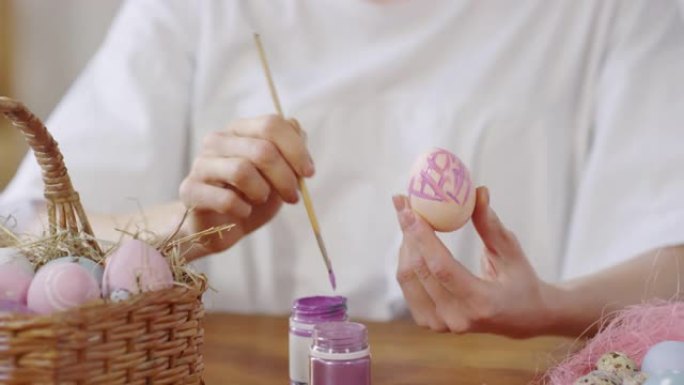 女人在复活节彩蛋上绘画的手