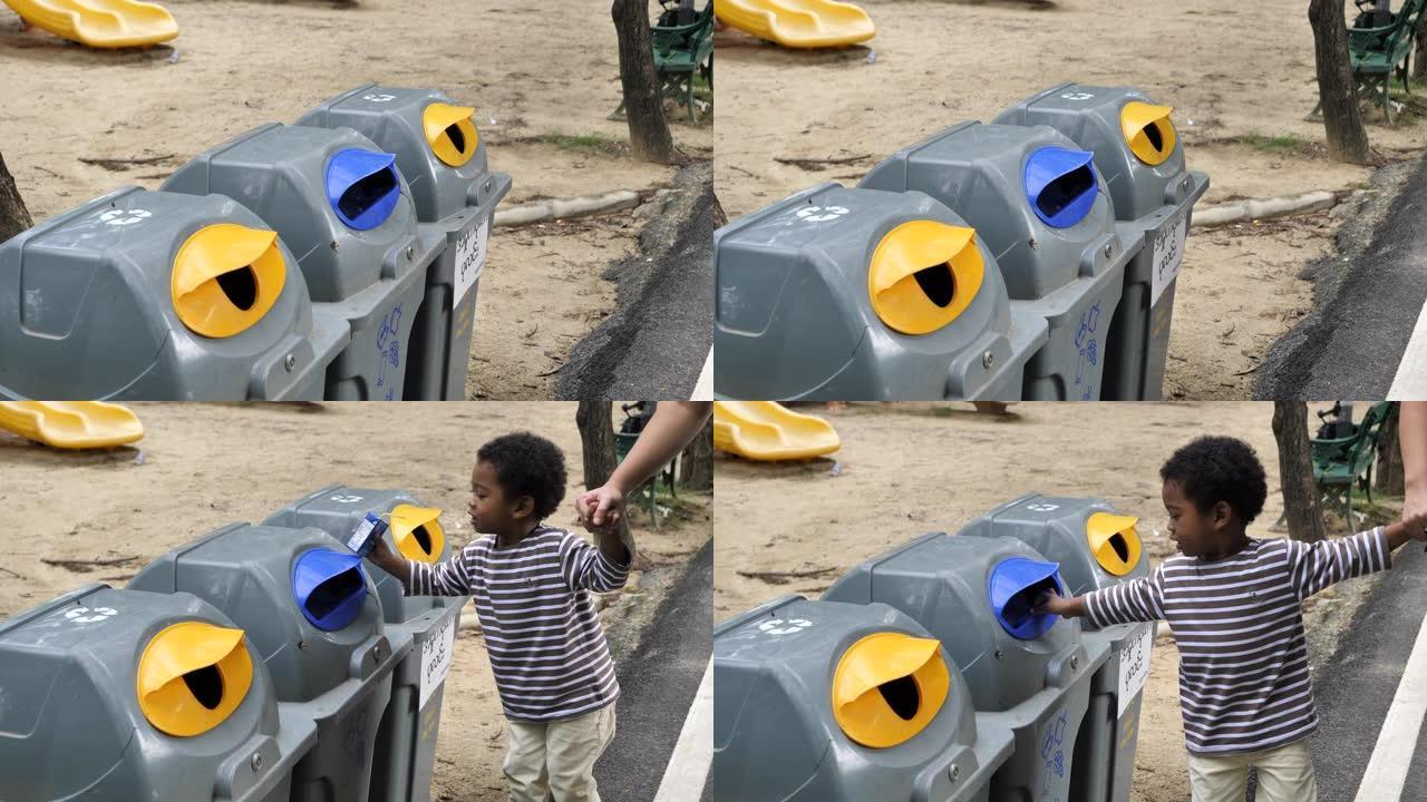 亚洲男婴将塑料瓶扔进可回收垃圾箱