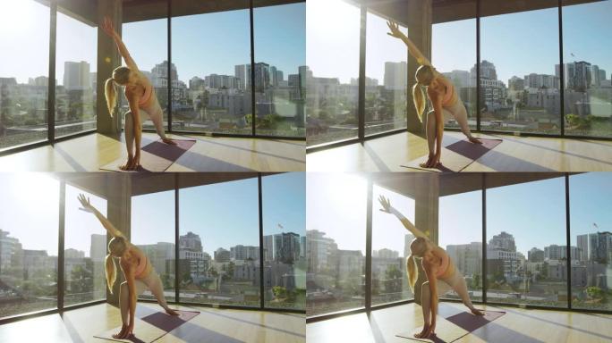 日出时慢动作美女在城市瑜伽馆表演瑜伽姿势