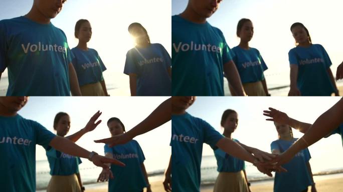 快乐志愿者站在沙滩上做圈，团结协作理念