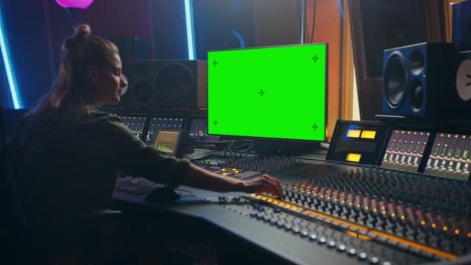 在音乐唱片公司工作的时尚女性音频工程师/制作人的肖像，使用绿屏计算机，调音台，控制台来创作新歌。女艺