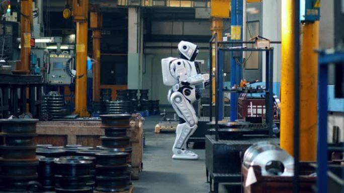 仿生机器人走在工厂的房间里，在平板电脑上打字。