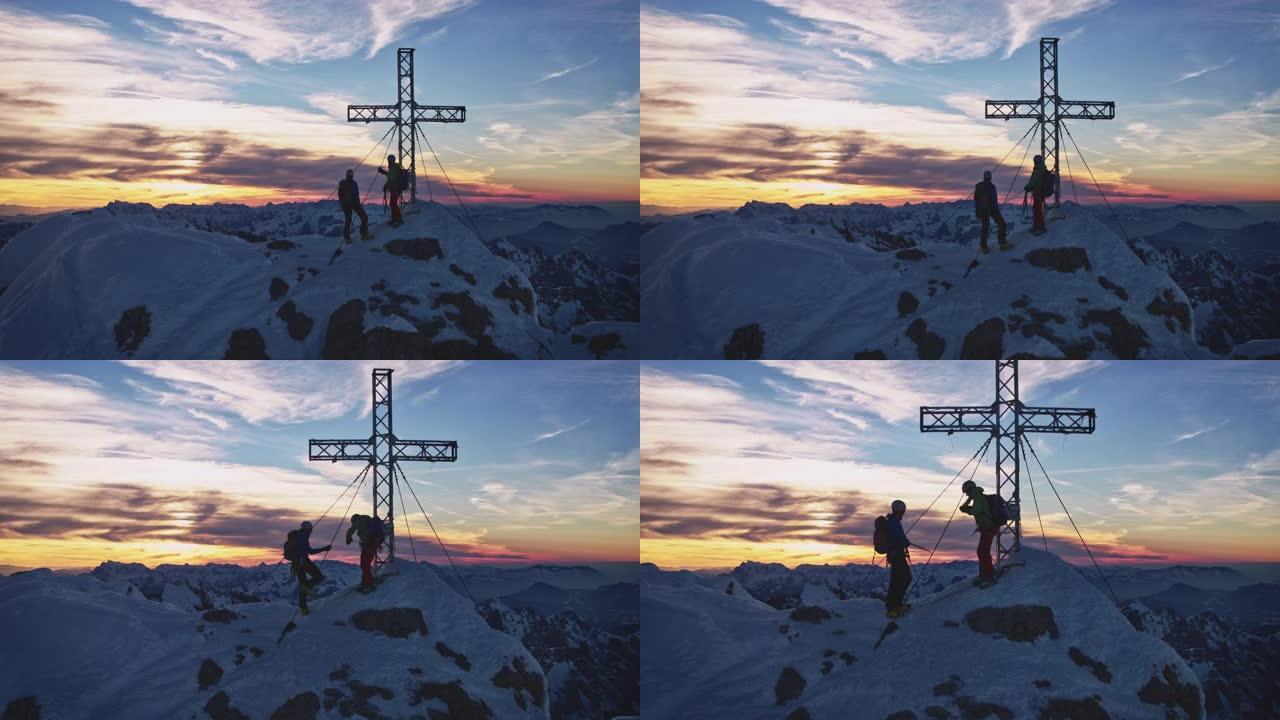 日出时，山顶上的徒步旅行者在天空的映衬下穿过