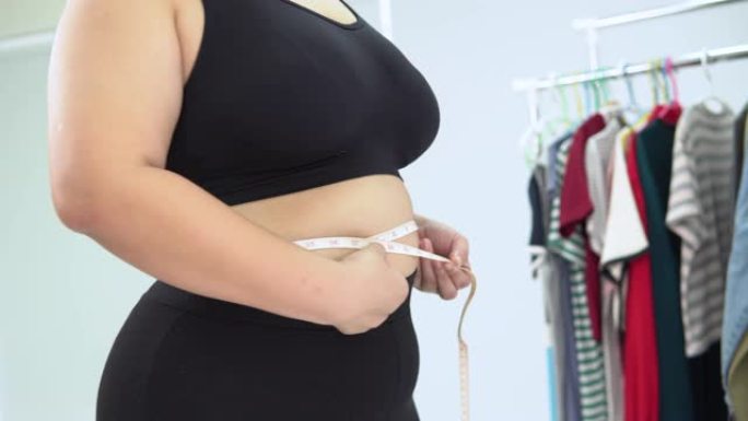 测量腹部周长的大型亚洲女性