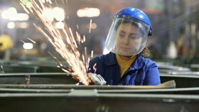 在金属制造厂使用研磨机的女工