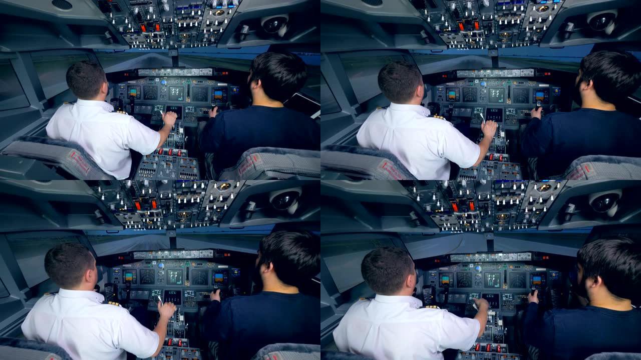 两名男子正在飞行模拟机中练习着陆
