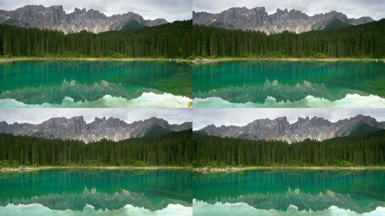 意大利多洛米蒂瓦迪法萨地区的Carezza湖 (爱抚湖)。湖泊、树木和落基山脉的景观。平移镜头，4K