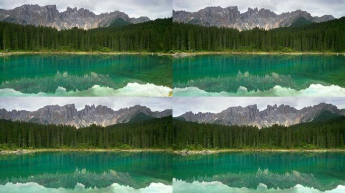 意大利多洛米蒂瓦迪法萨地区的Carezza湖 (爱抚湖)。湖泊、树木和落基山脉的景观。平移镜头，4K