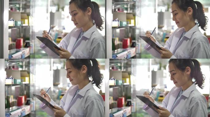 亚洲药剂师在药房中使用数字平板电脑
