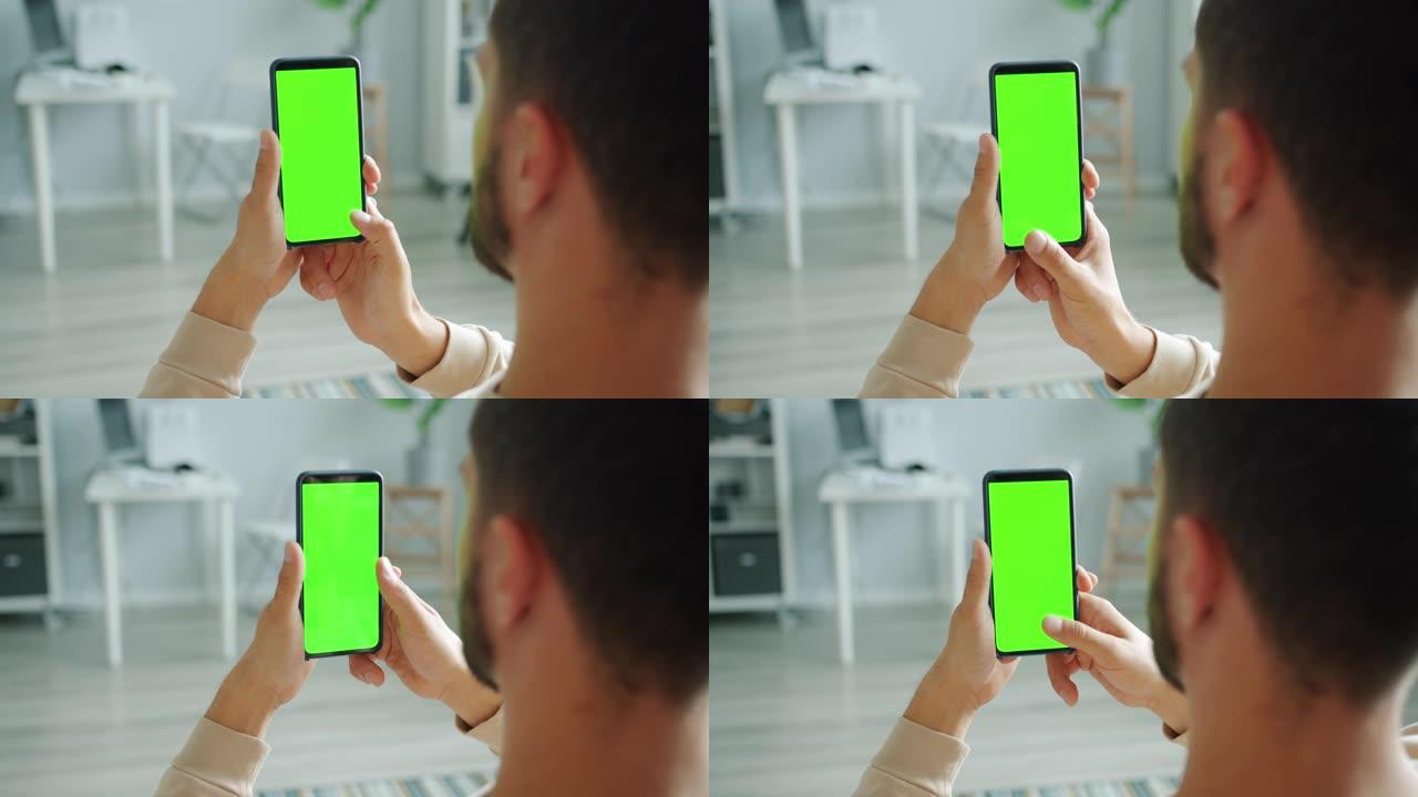 绿屏触摸浏览的男性手刷智能手机慢动作