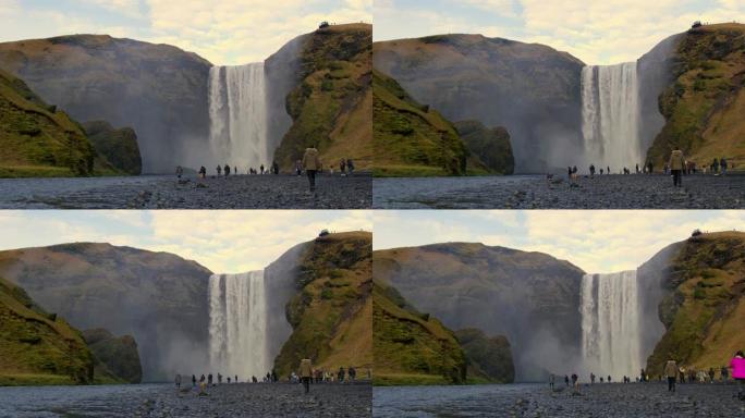 WS游客站在冰岛Skogafoss瀑布下，