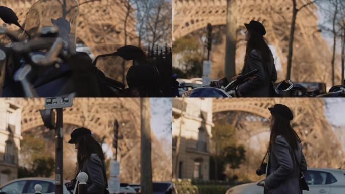 快乐优雅的旅游女人在埃菲尔铁塔附近的巴黎街上行走的侧跟踪镜头，用踏板车慢动作