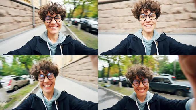 迷人的女孩在街上开心的肖像微笑着笑着看着相机，在城市的人行道上转身说话。幸福和青春的概念。
