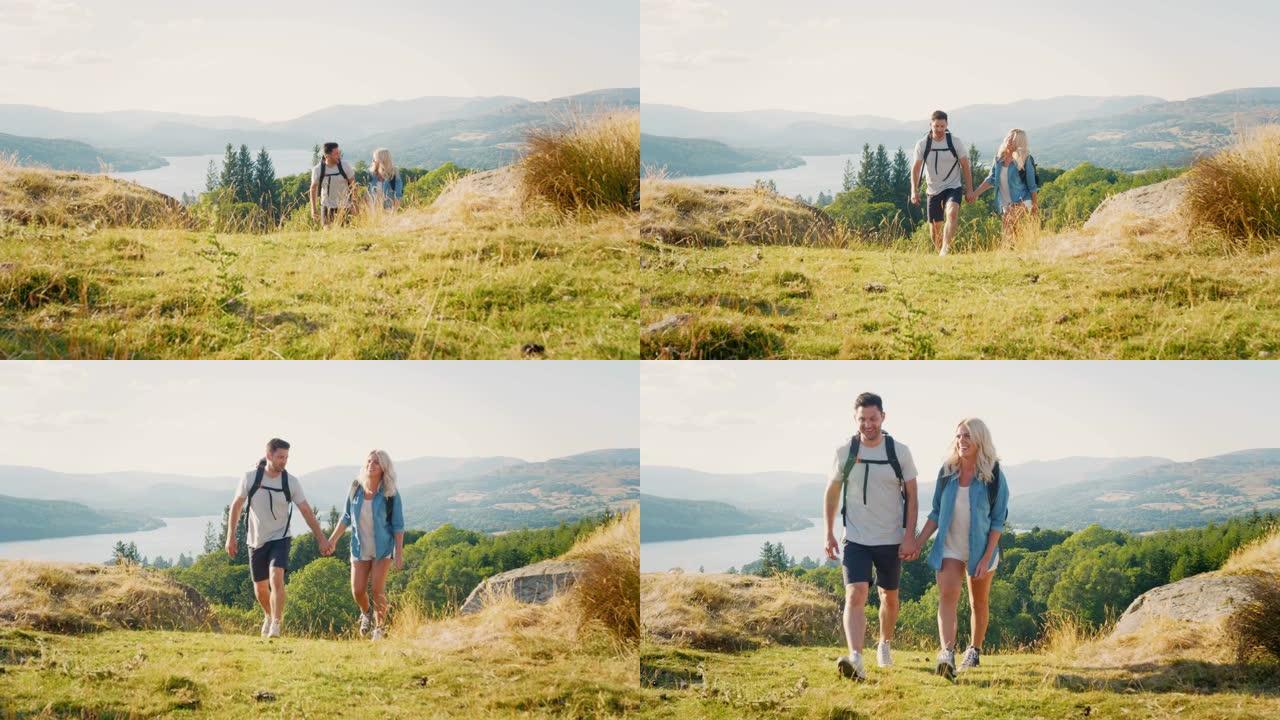 夫妇一起爬山穿越英国湖区乡村的慢动作镜头