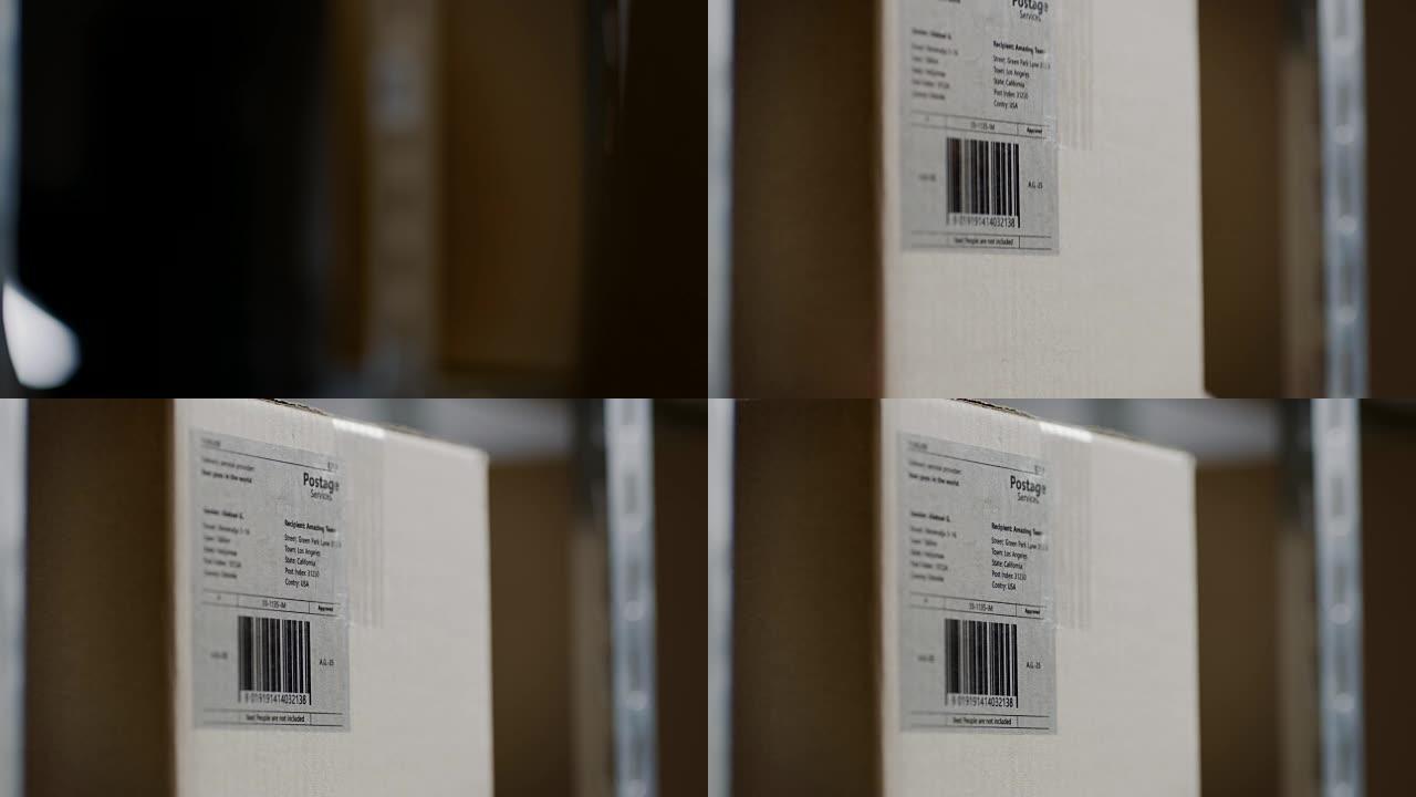 工人手中的特写镜头放置有标记的纸板箱，将架子包装在仓库中。