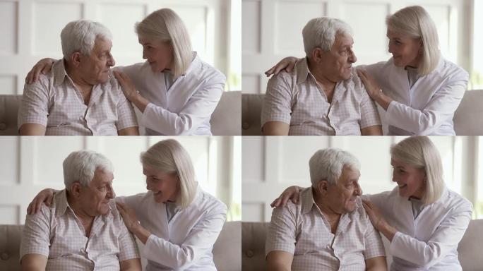 成熟的女性护士与老人交谈帮助解决问题