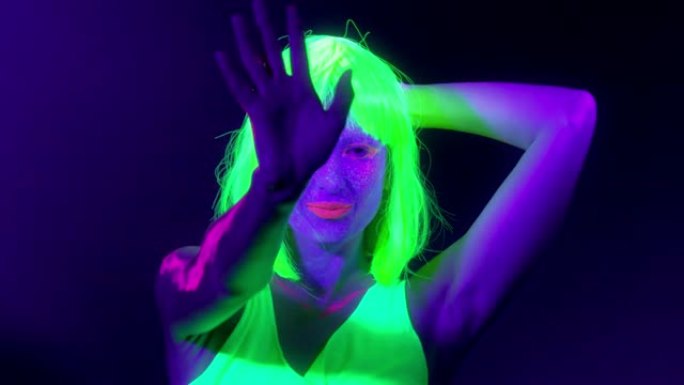 在霓虹灯下跳舞的美丽性感女性的慢镜头。夜总会，派对概念。