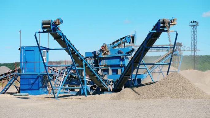 采矿业设备。蓝色破碎机在采石场用碎石工作。