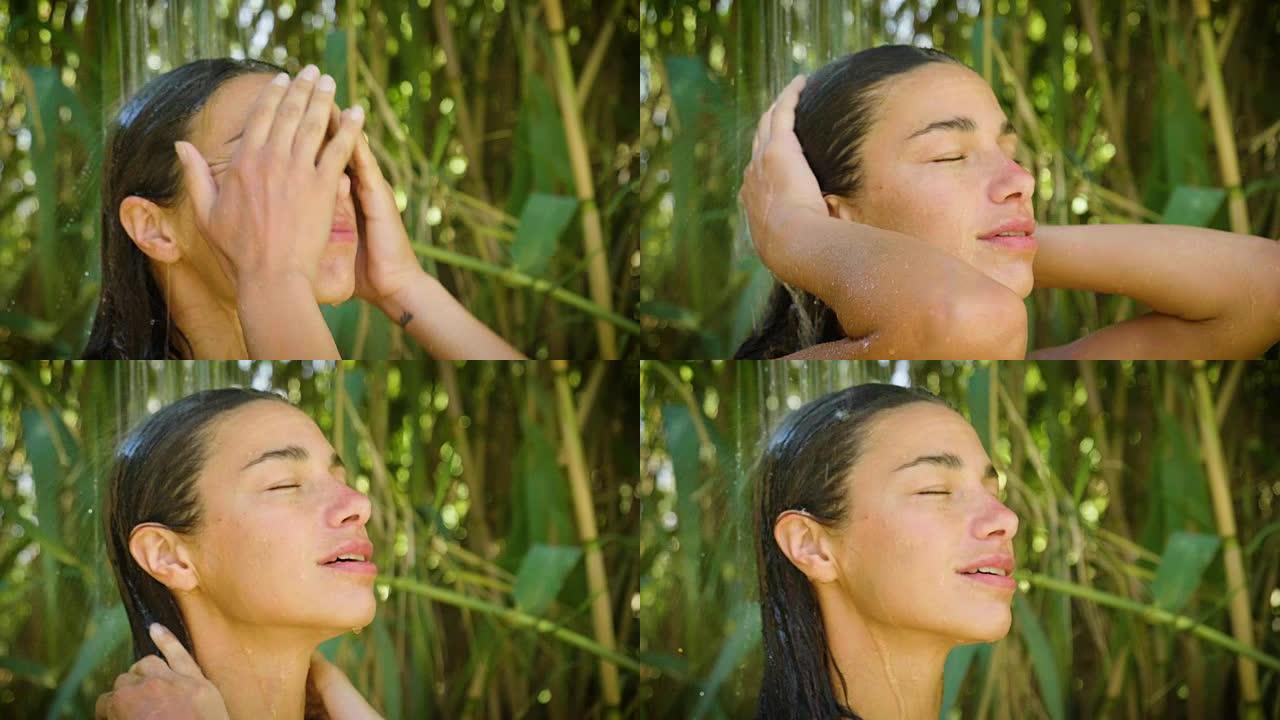 大自然中年轻美丽的女孩在温暖透明的热带瀑布中自然淋浴下洗涤。
