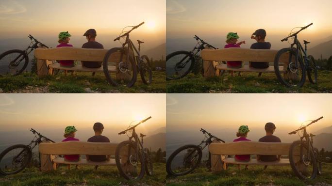 镜头耀斑: 年轻的骑自行车的人在日落后坐在长凳上，拳头撞了一下。